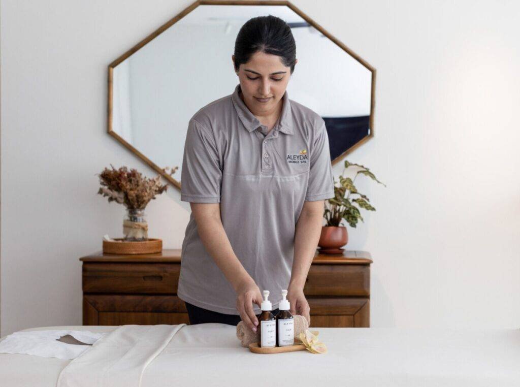 home spa therapist arranging products on a bed