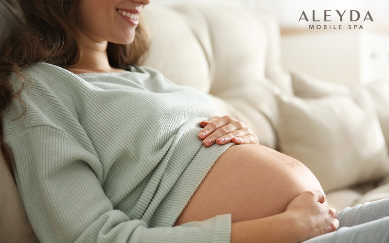 Pregnant Lady On Third Trimester Touching Her Belly By Hands And Smiling