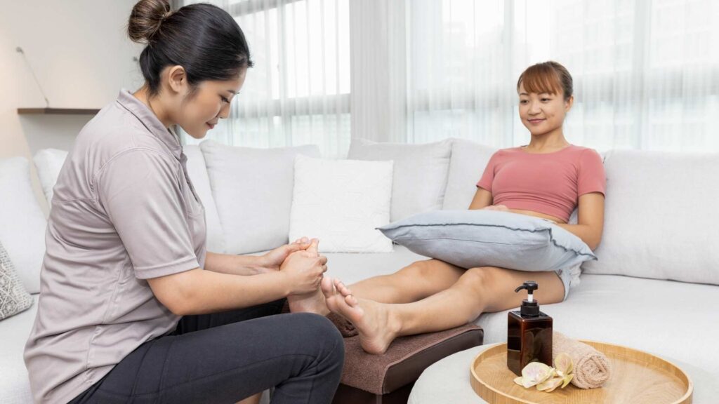 Home massage- Therapist providing foot reflexology