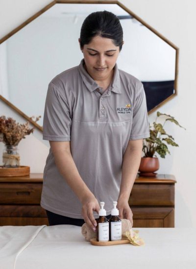 home spa therapist arranging products on a bed